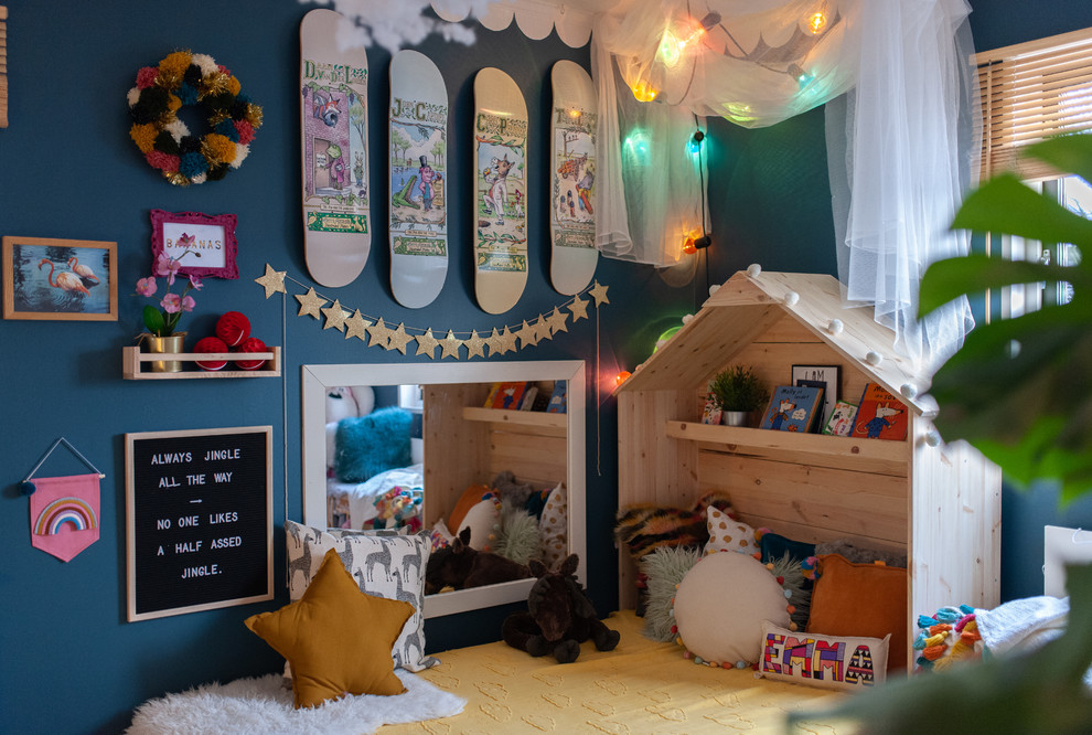 This is an example of an eclectic kids' room for girls in Stockholm with blue walls.