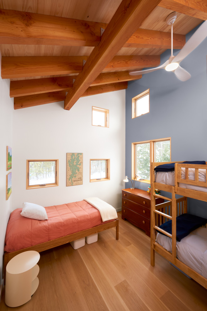 Foto på ett mellanstort rustikt könsneutralt barnrum kombinerat med sovrum, med blå väggar och mellanmörkt trägolv