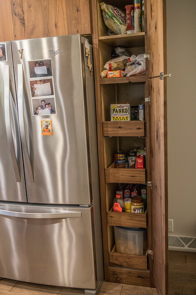 Small minimalist galley medium tone wood floor and brown floor eat-in kitchen photo in Wichita with a drop-in sink, flat-panel cabinets, brown cabinets, quartzite countertops, white backsplash, glass tile backsplash, stainless steel appliances and a peninsula