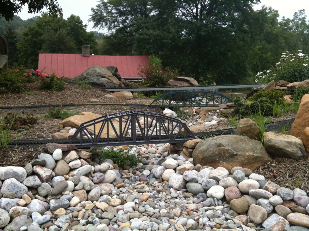 Design ideas for a large rustic partial sun backyard stone formal garden for summer.