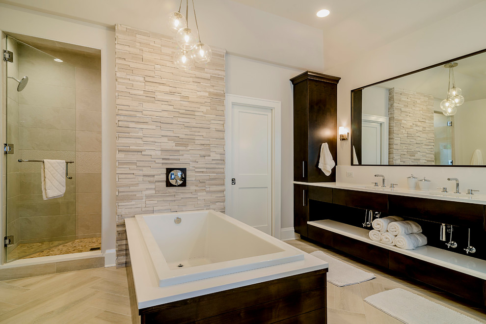 This is an example of a large modern master bathroom in Chicago with flat-panel cabinets, dark wood cabinets, a drop-in tub, an alcove shower, a two-piece toilet, beige tile, stone tile, beige walls, an undermount sink, engineered quartz benchtops and ceramic floors.