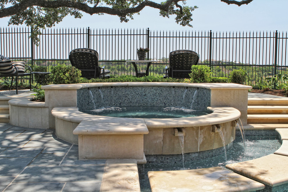 Photo of a mid-sized traditional backyard custom-shaped pool in Austin with a hot tub and natural stone pavers.