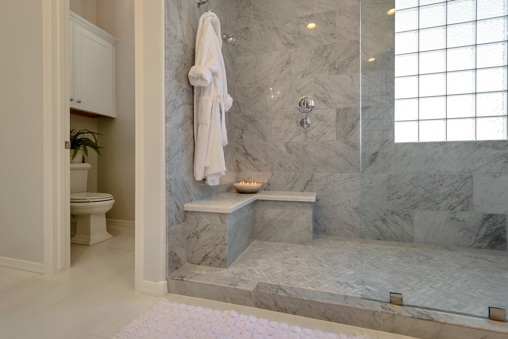Large transitional master gray tile and marble tile porcelain tile and gray floor freestanding bathtub photo in Phoenix with recessed-panel cabinets, white cabinets, gray walls, a drop-in sink, quartz countertops and white countertops