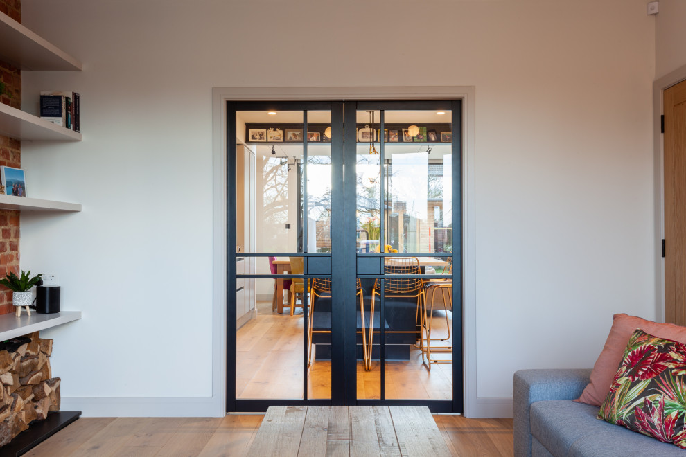 Inspiration for a medium sized modern open plan living room in London with light hardwood flooring.