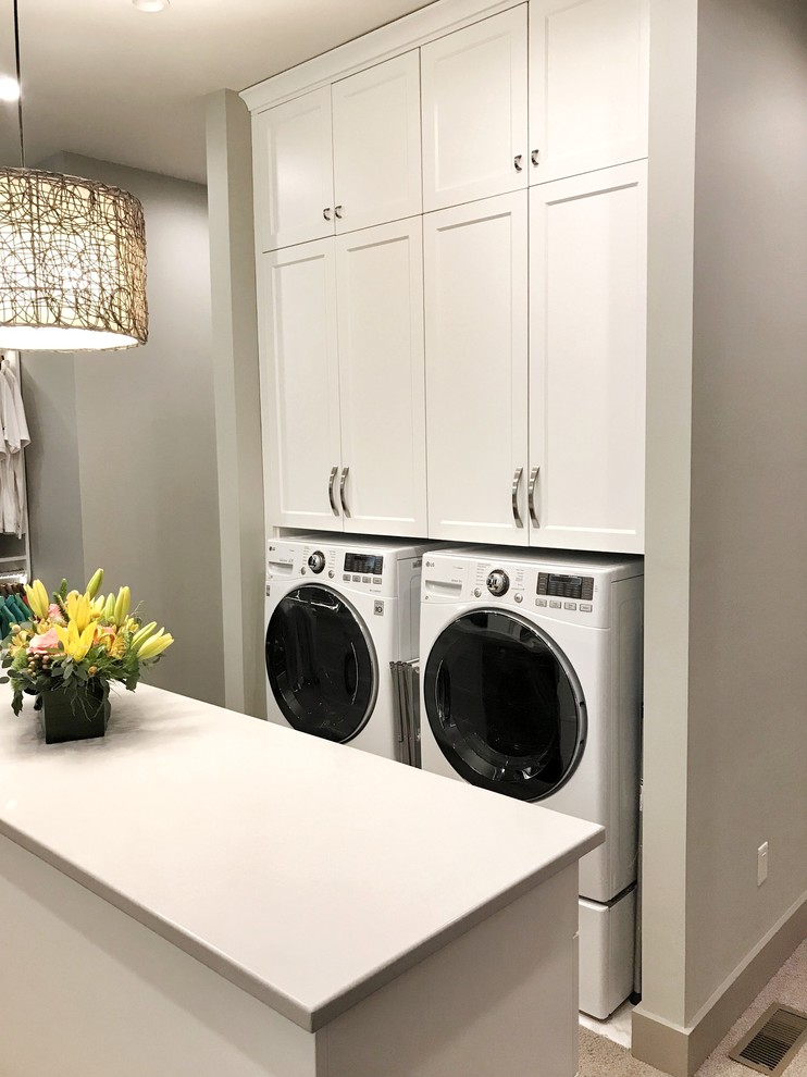 This is an example of a large transitional laundry room in Other with flat-panel cabinets, white cabinets, carpet and beige floor.