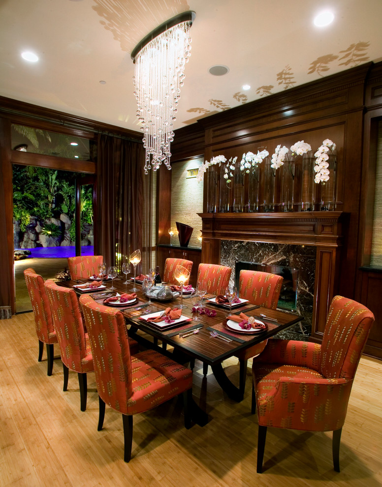 Inspiration for a large tropical open plan dining in Orange County with beige walls, bamboo floors, a standard fireplace, a stone fireplace surround and beige floor.