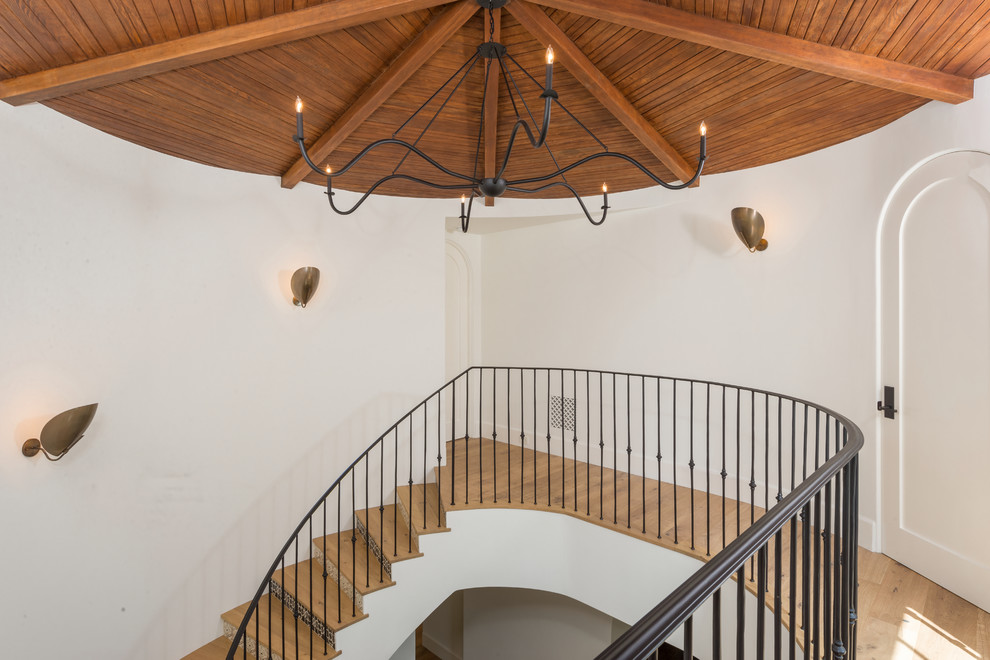 Inspiration for a mediterranean wood staircase in Los Angeles with tile risers and metal railing.