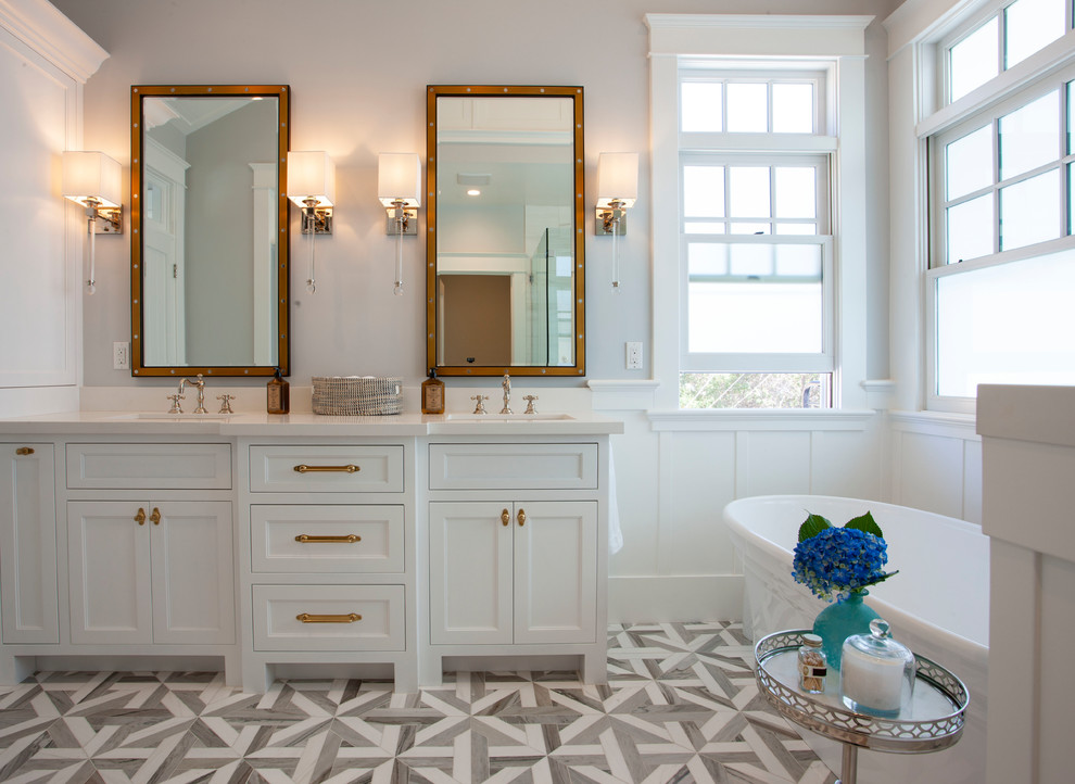 Large beach style master bathroom in San Diego with shaker cabinets, white cabinets, a freestanding tub, grey walls, ceramic floors, an undermount sink, engineered quartz benchtops, multi-coloured floor and white benchtops.
