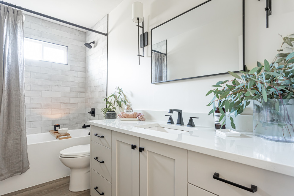This is an example of a mid-sized contemporary 3/4 bathroom in Vancouver with shaker cabinets, grey cabinets, an alcove tub, a one-piece toilet, gray tile, ceramic tile, white walls, vinyl floors, an undermount sink, quartzite benchtops, brown floor, multi-coloured benchtops, a single vanity and a built-in vanity.