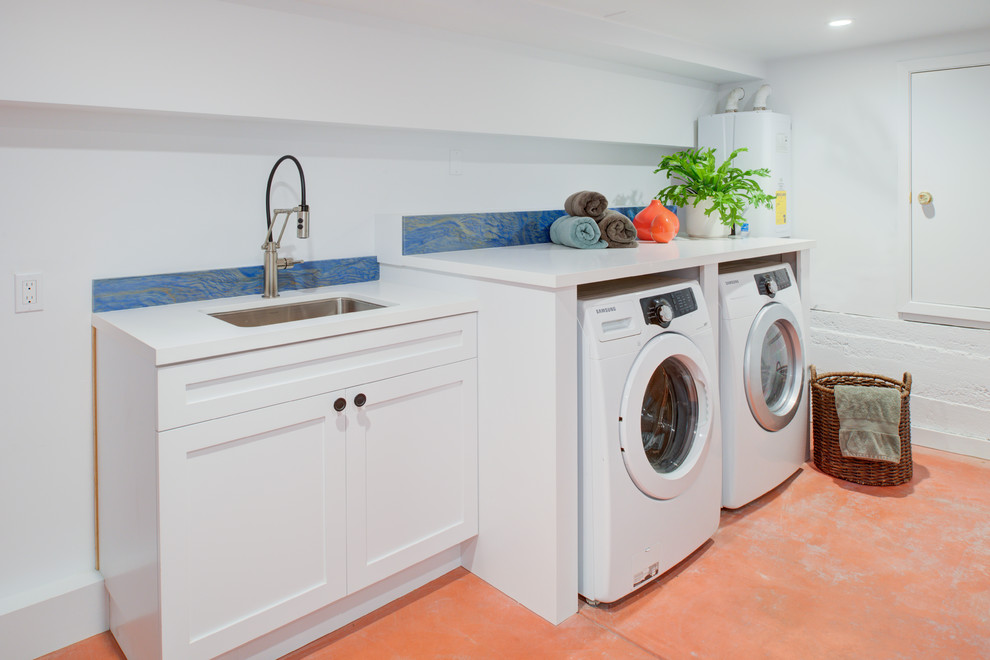 Design ideas for a large contemporary single-wall utility room in San Francisco with a drop-in sink, flat-panel cabinets, white cabinets, quartz benchtops, white walls, concrete floors, a side-by-side washer and dryer, orange floor and white benchtop.