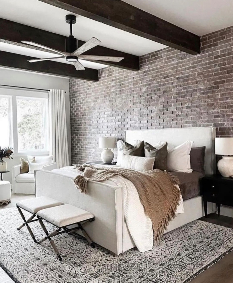 Großes Hauptschlafzimmer mit weißer Wandfarbe, braunem Holzboden, braunem Boden, freigelegten Dachbalken und Ziegelwänden in Dallas