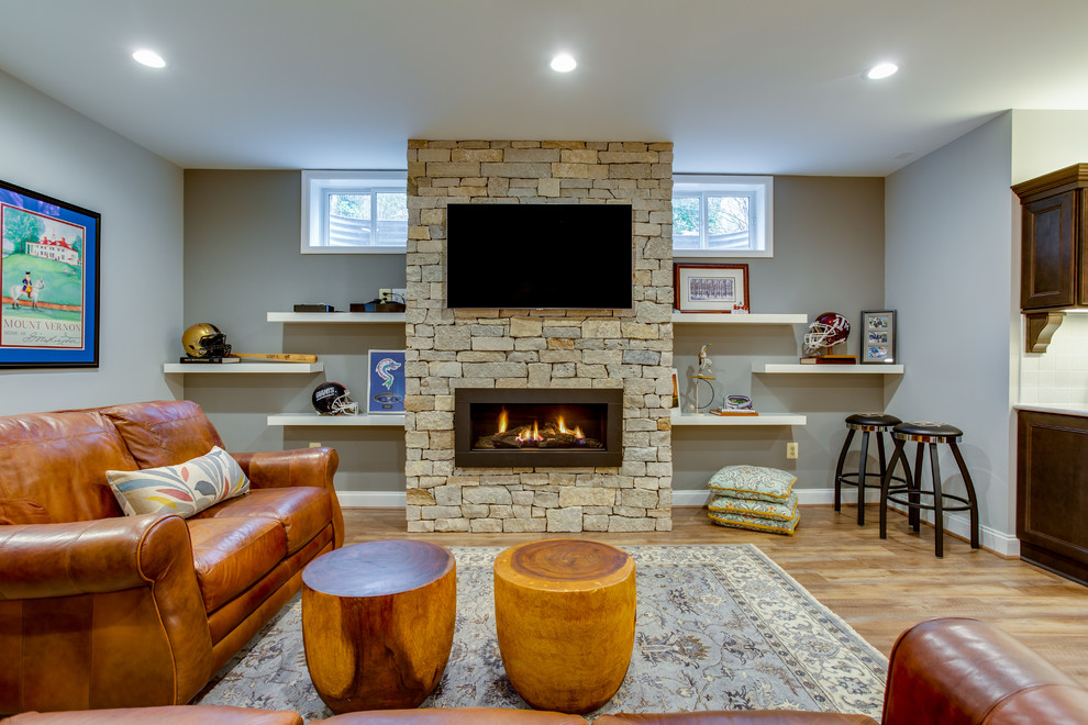 Expansive arts and crafts walk-out basement in DC Metro with vinyl floors, a standard fireplace and a stone fireplace surround.