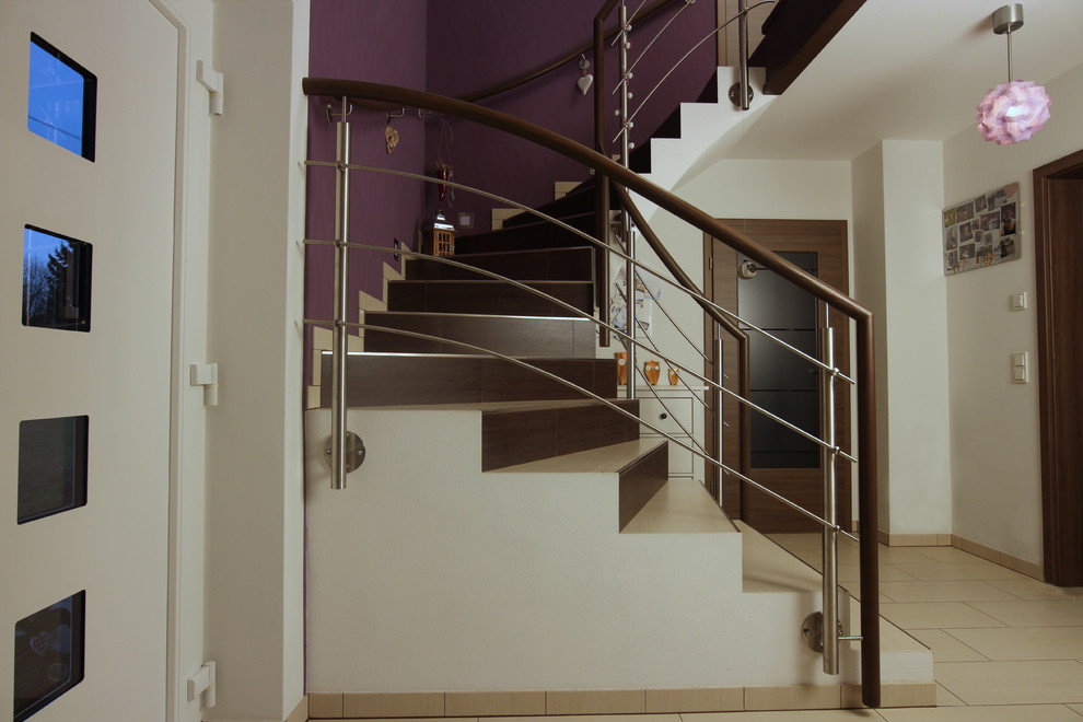 Gewendelte, Mittelgroße Moderne Treppe mit gefliesten Treppenstufen, gefliesten Setzstufen und Mix-Geländer in Dresden