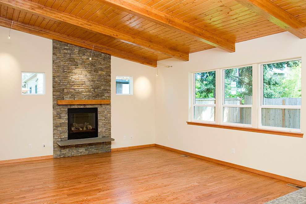 This is an example of a mid-sized traditional open concept living room in Seattle with white walls, medium hardwood floors, a standard fireplace and a stone fireplace surround.