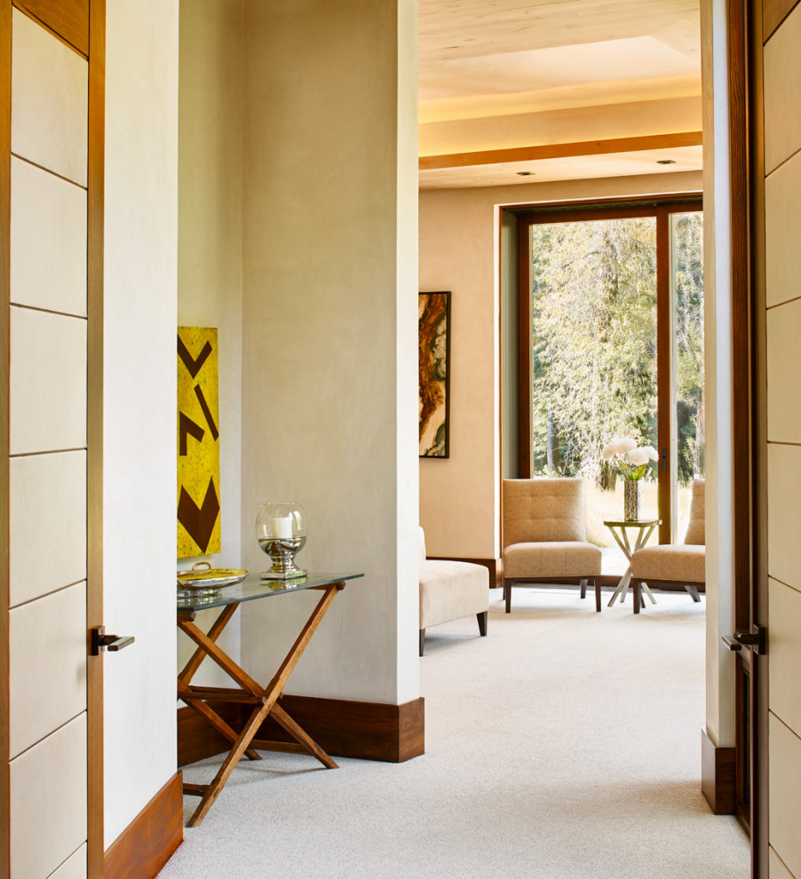 Example of a mid-sized trendy carpeted hallway design in Denver with beige walls