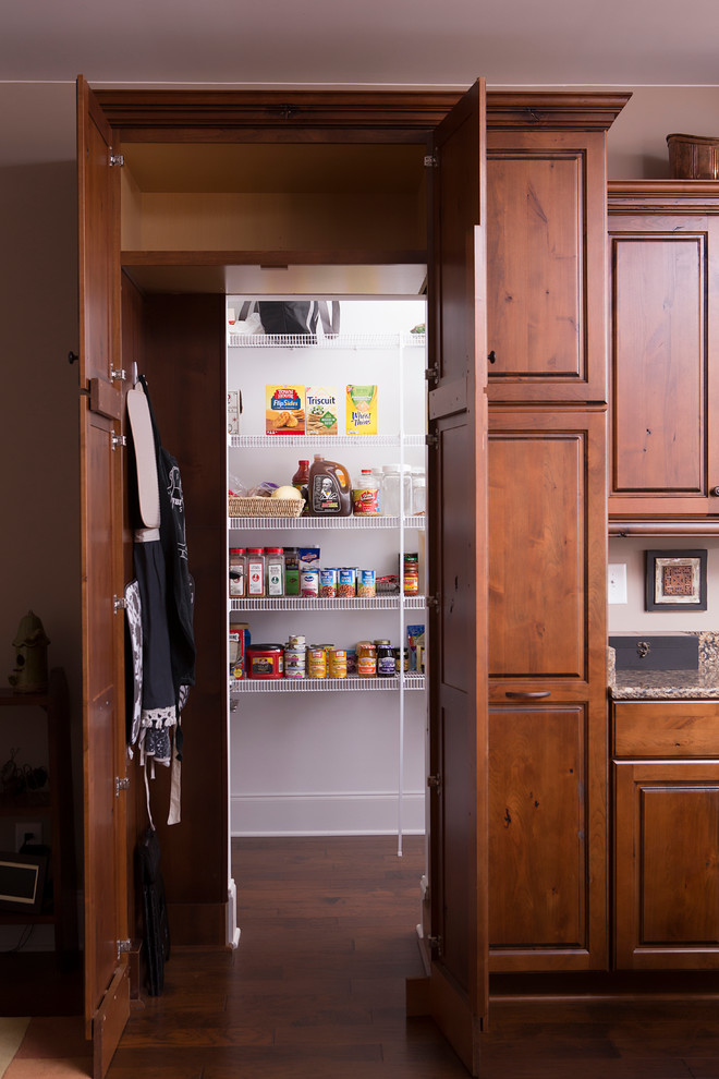 Mid-sized transitional l-shaped dark wood floor and brown floor kitchen pantry photo with raised-panel cabinets, medium tone wood cabinets, an undermount sink, granite countertops, stainless steel appliances and an island