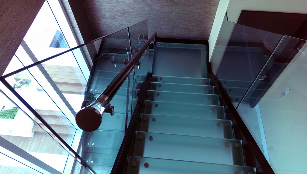 Design ideas for a large modern glass l-shaped staircase in Tampa with open risers and glass railing.