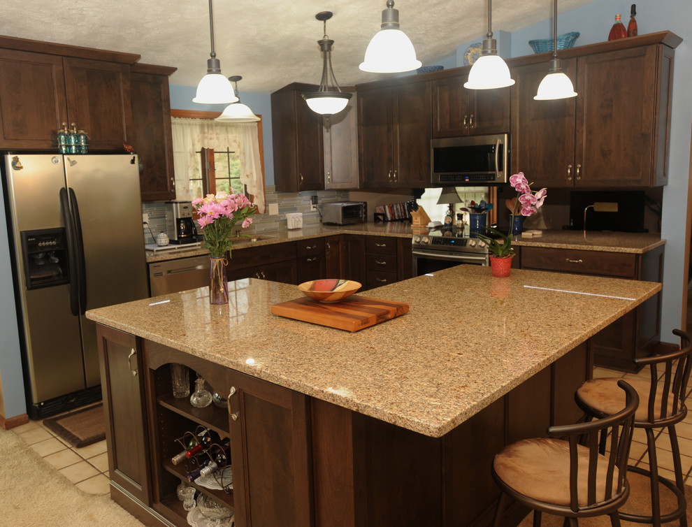 Inspiration for a mid-sized transitional l-shaped ceramic tile eat-in kitchen remodel with an undermount sink, recessed-panel cabinets, dark wood cabinets, granite countertops, multicolored backsplash, glass tile backsplash, stainless steel appliances and an island