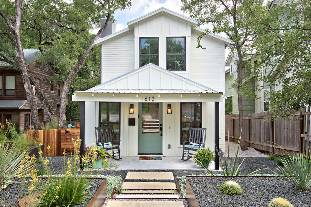Design ideas for a country two-storey white house exterior in Austin with wood siding.