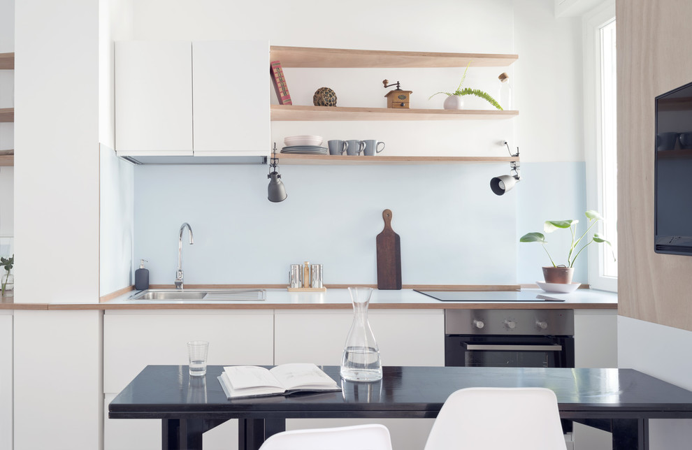 Design ideas for a small beach style single-wall eat-in kitchen in Other with a drop-in sink, flat-panel cabinets, white cabinets, wood benchtops, blue splashback, timber splashback, stainless steel appliances, laminate floors, no island and beige floor.