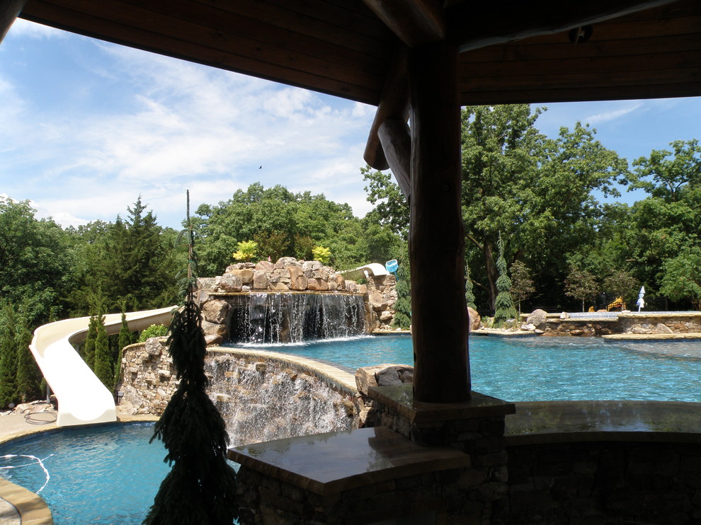 Inspiration for a mid-sized arts and crafts backyard custom-shaped pool in Kansas City with a water feature.
