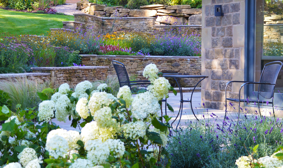 Inspiration for a large traditional patio in Other with natural stone pavers.