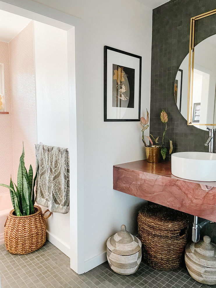 Photo of a mid-sized midcentury kids bathroom in Denver with an alcove tub, a shower/bathtub combo, gray tile, porcelain tile, white walls, porcelain floors, a vessel sink, marble benchtops, grey floor, a hinged shower door, pink benchtops, a single vanity and a floating vanity.