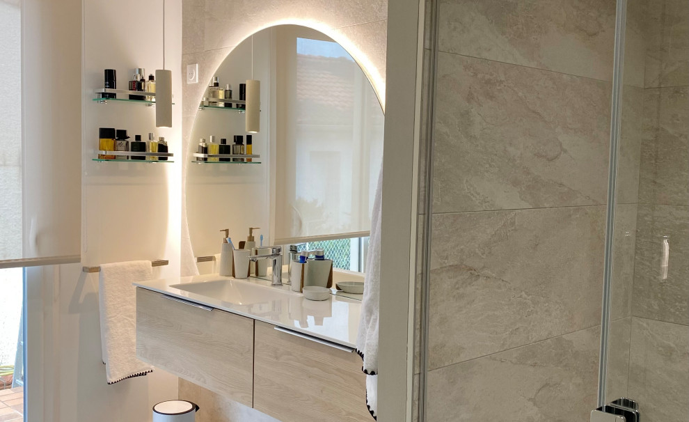 Inredning av ett modernt mellanstort vit vitt badrum med dusch, med luckor med profilerade fronter, skåp i ljust trä, en kantlös dusch, beige kakel, keramikplattor, beige väggar, linoleumgolv, ett väggmonterat handfat, bänkskiva i akrylsten, beiget golv och dusch med skjutdörr