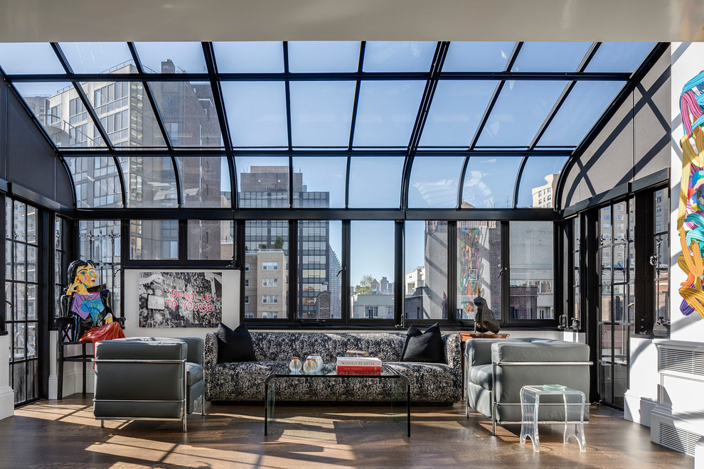 Photo of a contemporary sunroom in New York with dark hardwood floors, a glass ceiling and brown floor.
