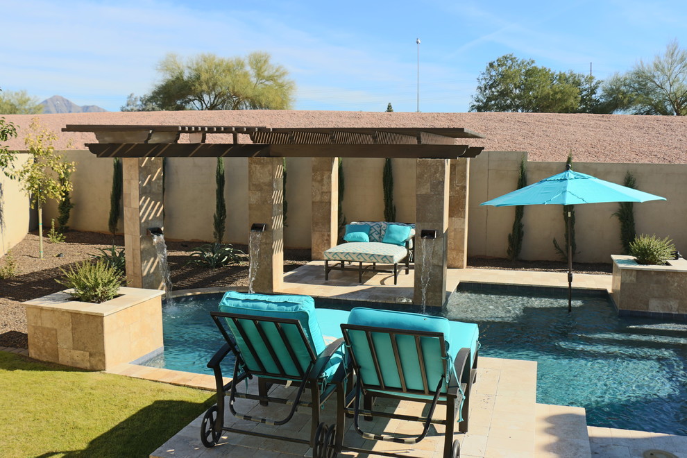 This is an example of a small modern courtyard custom-shaped natural pool in Phoenix with natural stone pavers.