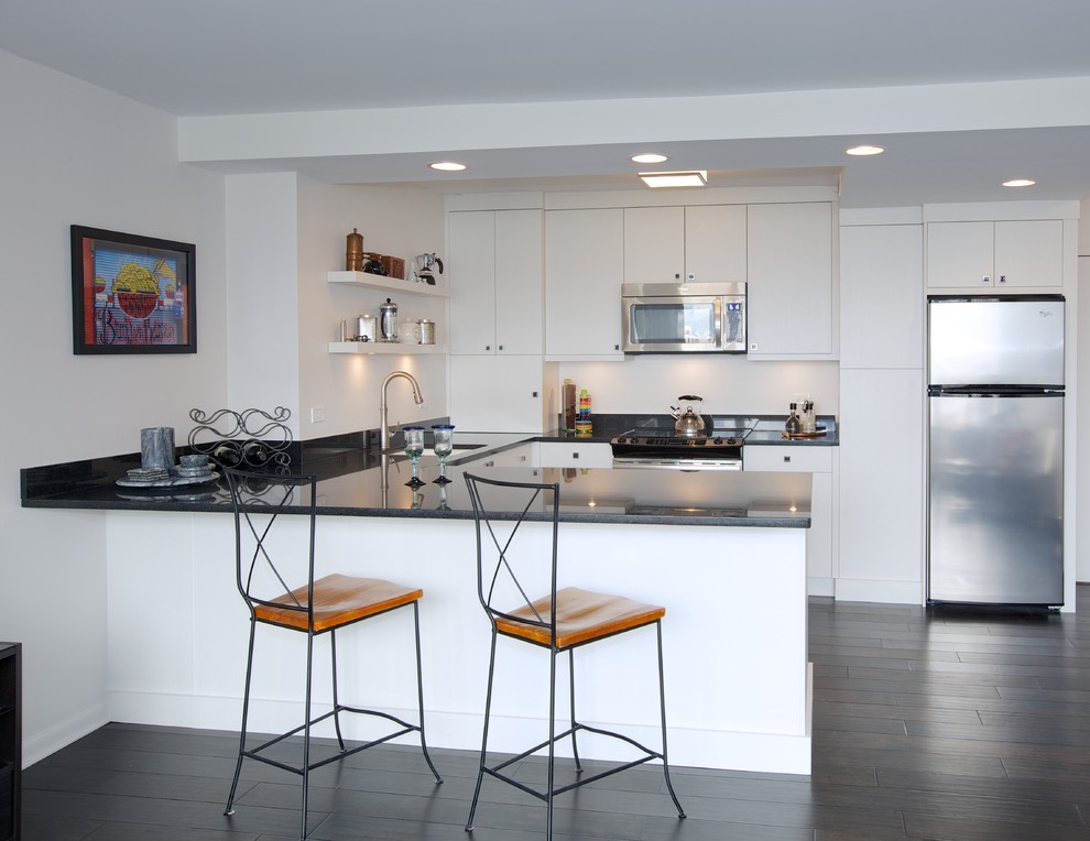 Photo of a small contemporary l-shaped open plan kitchen in Chicago with a drop-in sink, flat-panel cabinets, white cabinets, stainless steel appliances and no island.