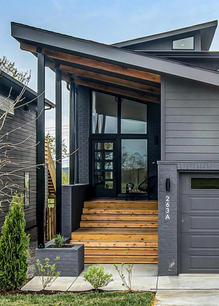 Medium sized and gey midcentury split-level detached house in Nashville with concrete fibreboard cladding, a lean-to roof, a shingle roof, a black roof and shiplap cladding.