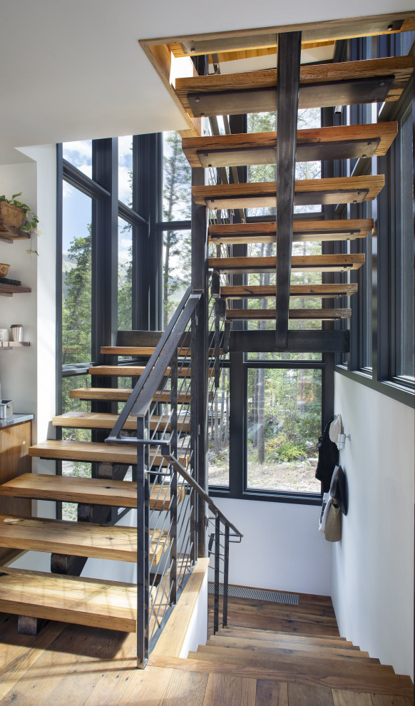 Photo of a contemporary wood u-shaped staircase in Denver with open risers and metal railing.