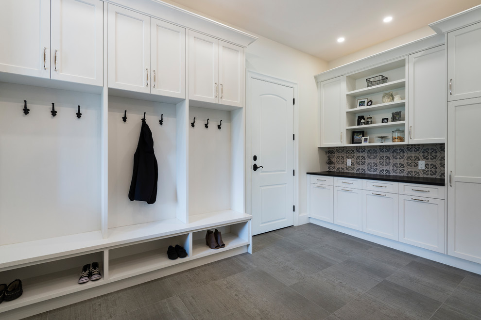 Large mediterranean dedicated laundry room in Vancouver with an undermount sink, white cabinets, quartz benchtops, white walls, porcelain floors, a side-by-side washer and dryer and grey floor.