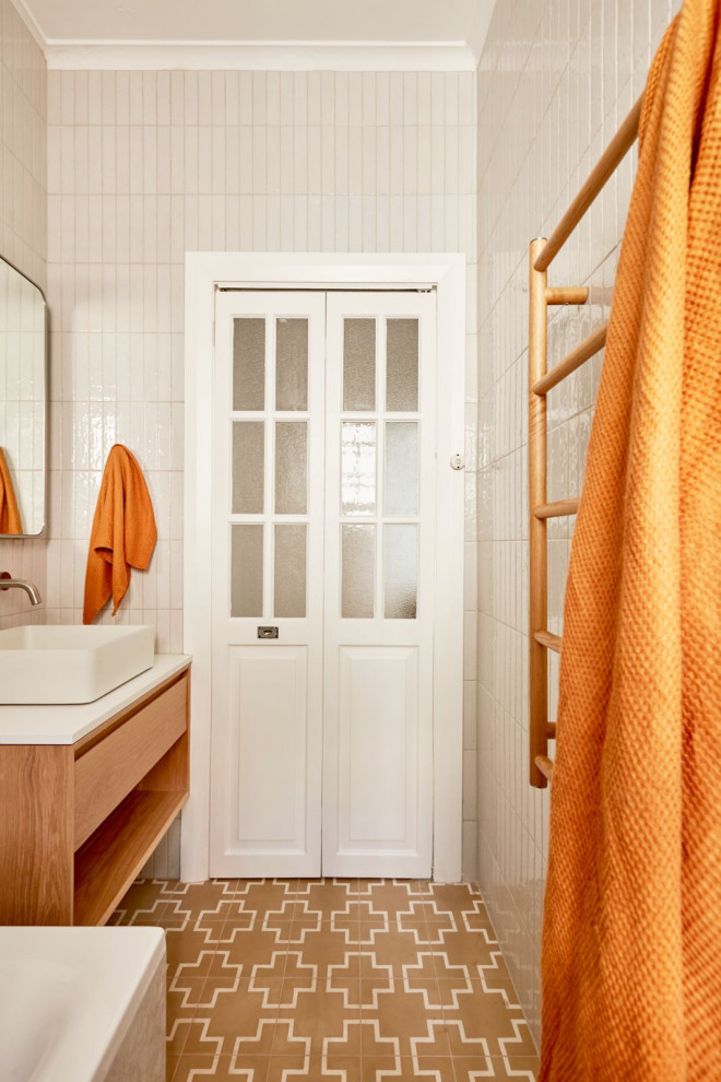 Inredning av ett eklektiskt vit vitt en-suite badrum, med skåp i mellenmörkt trä, ett platsbyggt badkar, en dusch/badkar-kombination, beige kakel, tunnelbanekakel, cementgolv, marmorbänkskiva och dusch med duschdraperi