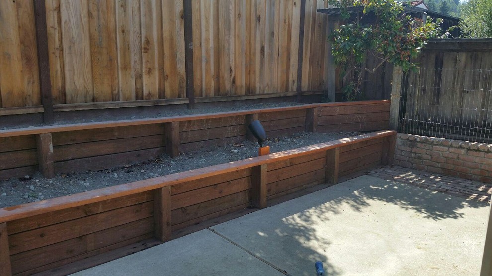 Photo of a mid-sized country backyard full sun garden in San Francisco with a retaining wall and concrete pavers.