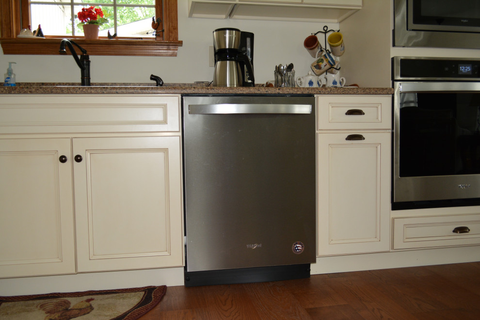 Example of a small transitional l-shaped medium tone wood floor and brown floor eat-in kitchen design with an undermount sink, flat-panel cabinets, beige cabinets, quartz countertops, stainless steel appliances, an island and brown countertops