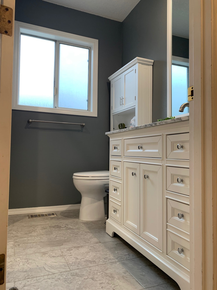 Photo of a small family bathroom in Portland with shaker cabinets, white cabinets, an alcove bath, a two-piece toilet, grey walls, vinyl flooring, an integrated sink, solid surface worktops, grey floors, white worktops, a single sink and a freestanding vanity unit.