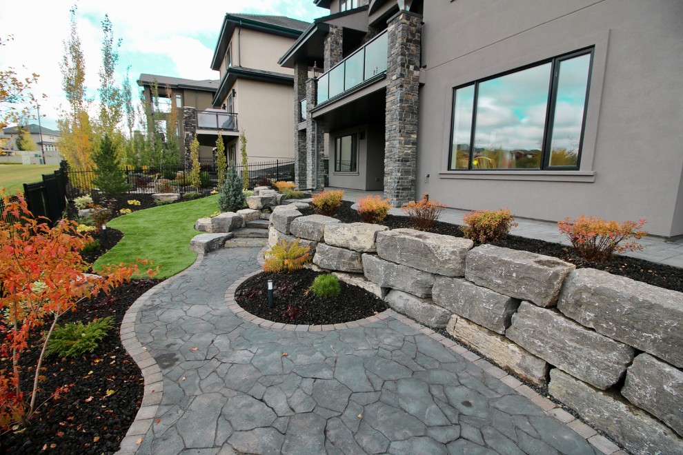 Design ideas for a large rustic shade backyard concrete paver retaining wall landscape in Edmonton for fall.
