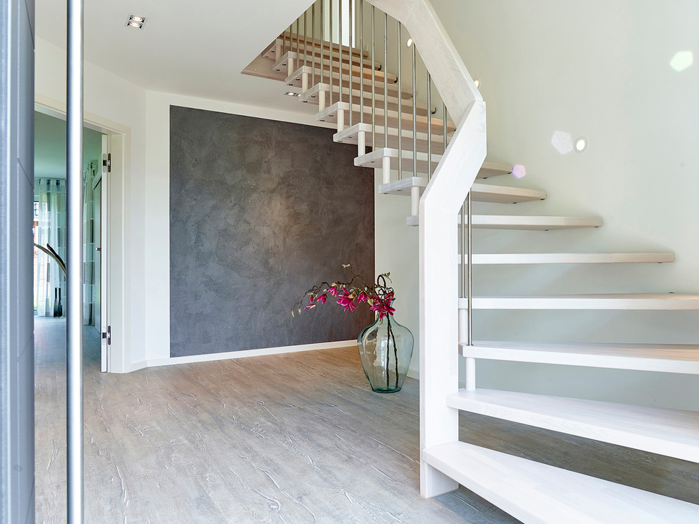 Großer Moderner Flur mit grauer Wandfarbe, dunklem Holzboden und grauem Boden in Hamburg