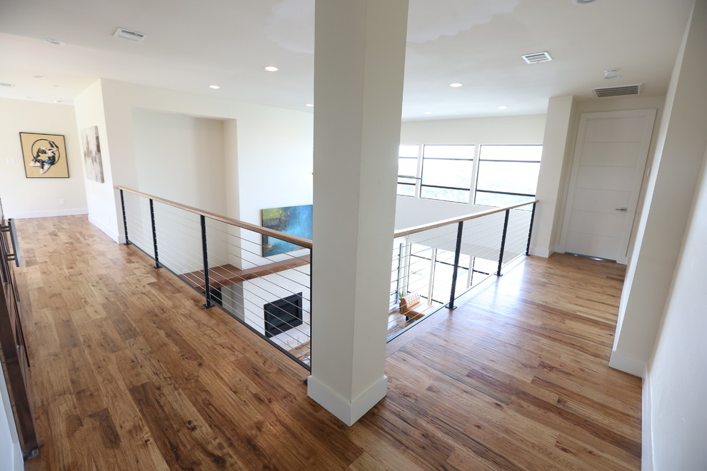 Mid-sized contemporary hallway in Dallas with white walls, medium hardwood floors and brown floor.