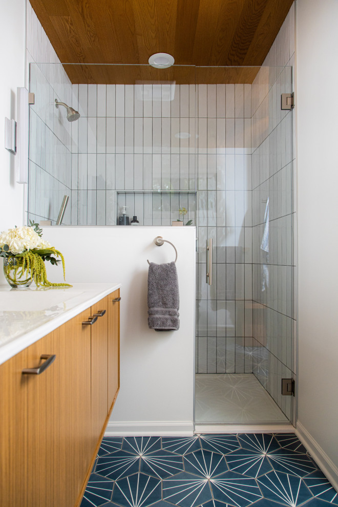 This is an example of a midcentury master bathroom in Kansas City with flat-panel cabinets, light wood cabinets, a curbless shower, white tile, ceramic tile, white walls, cement tiles, an integrated sink, blue floor, a hinged shower door, white benchtops, a niche, a single vanity, a floating vanity and wood.