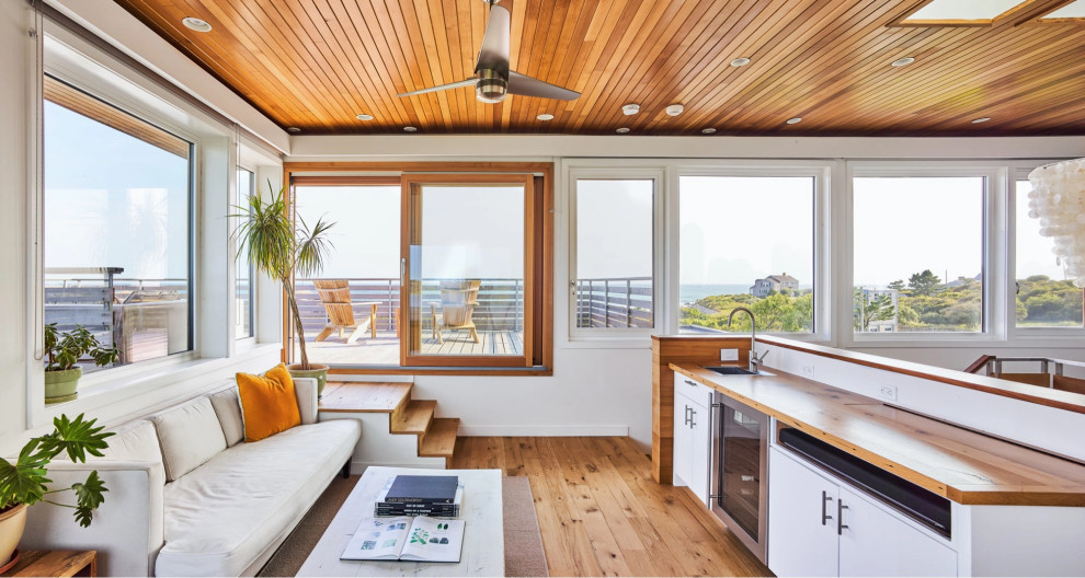 Foto di un soggiorno stile marinaro aperto con pavimento in legno massello medio e soffitto in legno