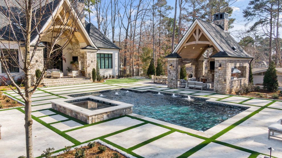 Foto de piscina clásica renovada grande rectangular en patio trasero con adoquines de piedra natural
