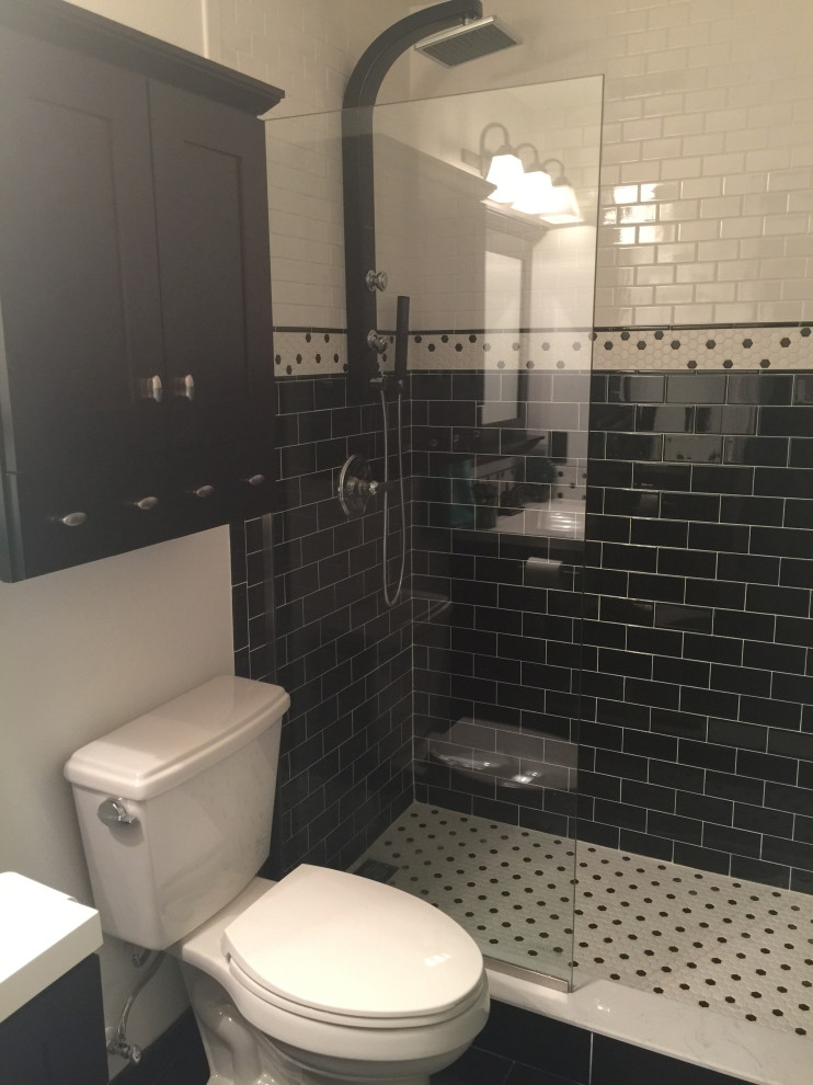 Inspiration for a mid-sized eclectic 3/4 bathroom in Tampa with shaker cabinets, black cabinets, an open shower, a two-piece toilet, black and white tile, ceramic tile, white walls, ceramic floors, an undermount sink, solid surface benchtops, black floor, an open shower, white benchtops, a niche, a single vanity and a built-in vanity.