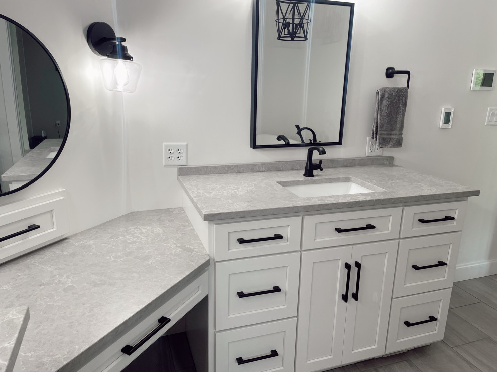 Modelo de cuarto de baño principal y único moderno pequeño con puertas de armario blancas, encimera de cuarzo compacto y encimeras grises