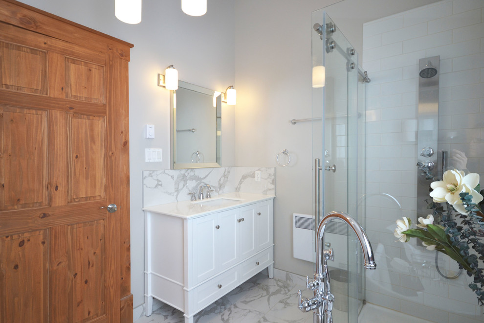 Freestanding bathtub - large transitional master white tile and subway tile marble floor and white floor freestanding bathtub idea in Ottawa with shaker cabinets, white cabinets, a two-piece toilet, gray walls, an undermount sink, marble countertops and a hinged shower door