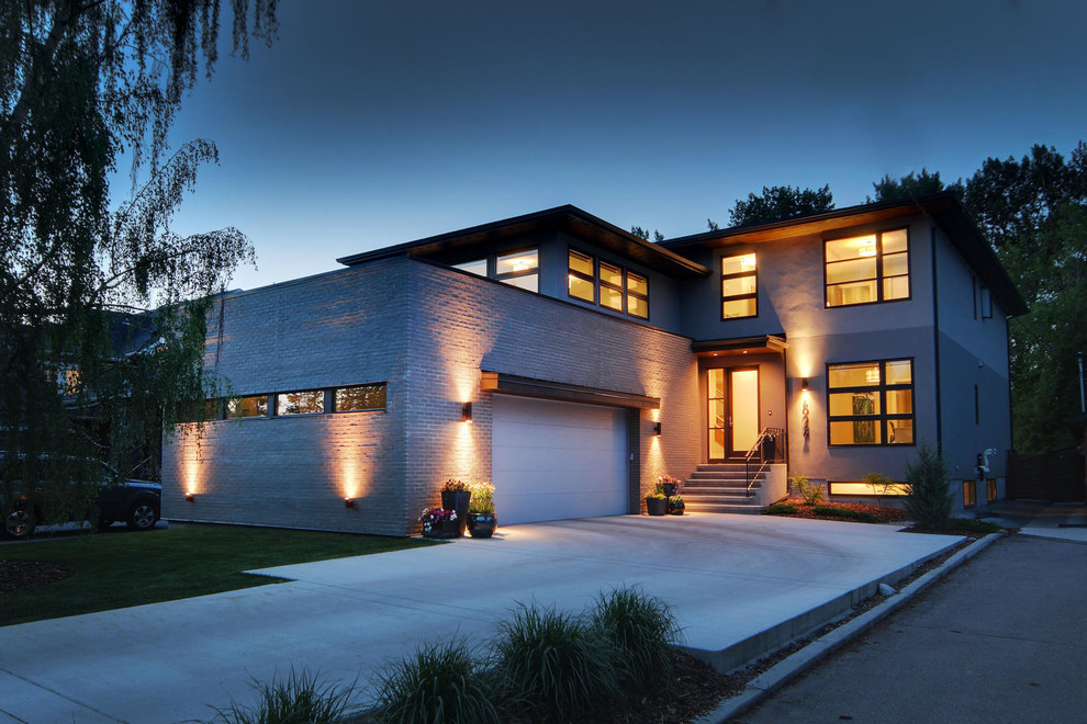 Inspiration for a large transitional two-story stucco gray home design remodel in Calgary with a hip roof and a shingle roof