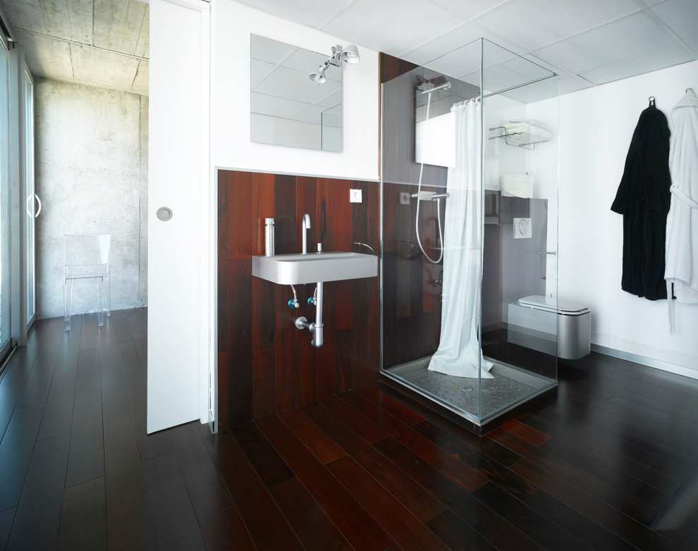 Design ideas for a mid-sized contemporary master bathroom in Other with a one-piece toilet, dark hardwood floors, white walls and a wall-mount sink.