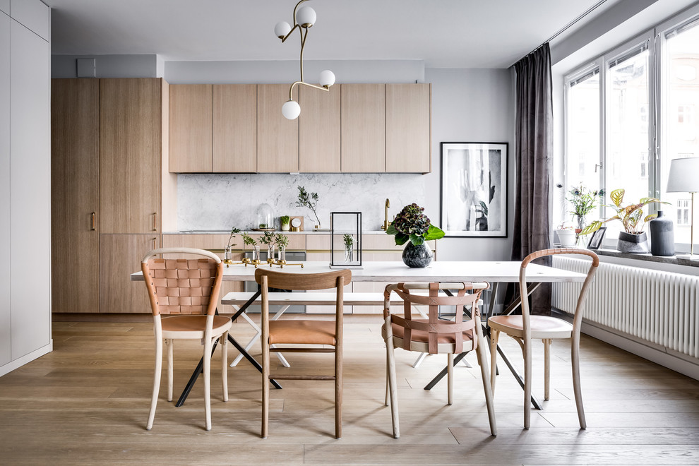 Scandinavian open plan dining in Stockholm with white walls, light hardwood floors and beige floor.